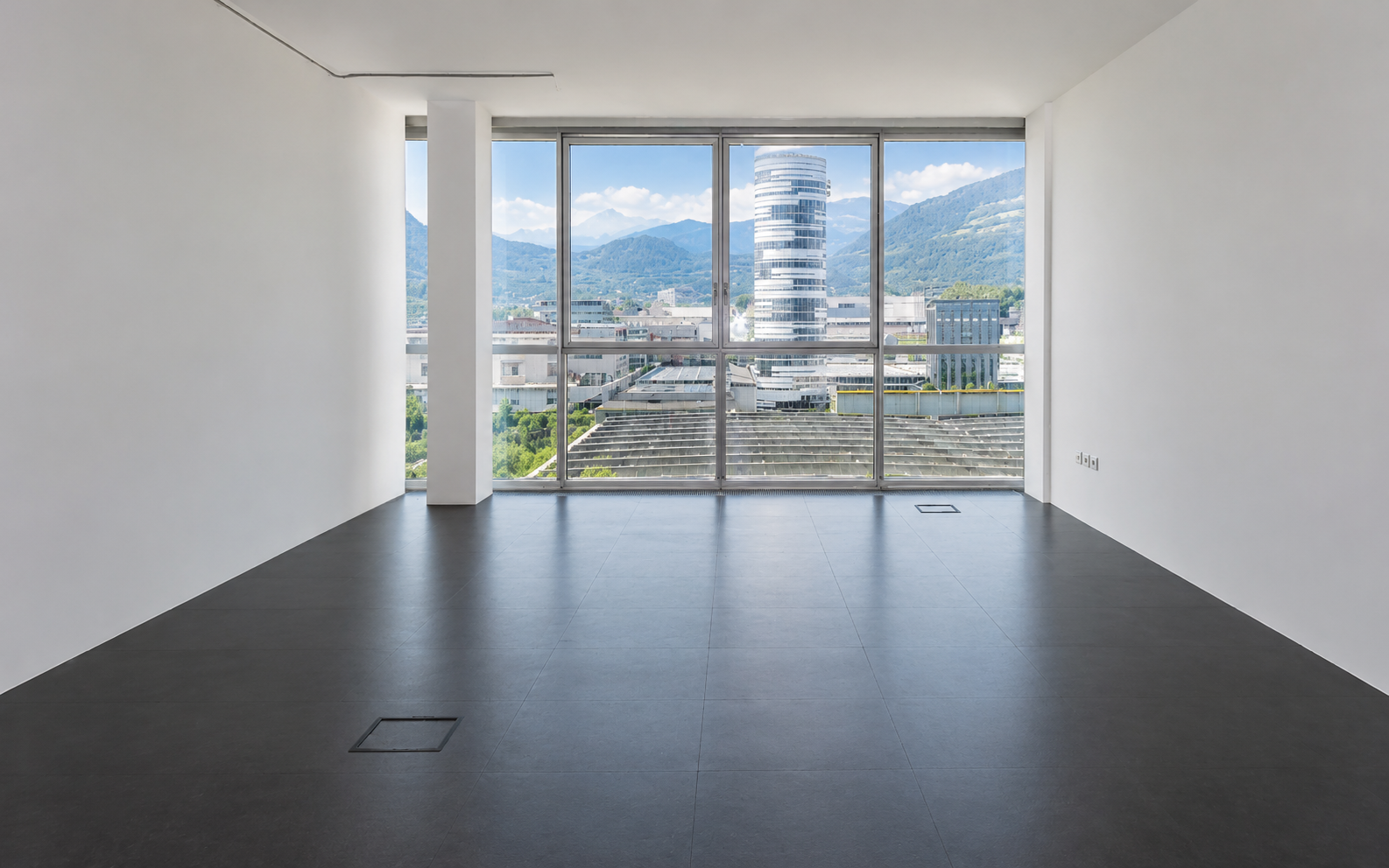 Heller Büroraum mit Panoramafenster im Syncom-Gebäude in Brixen